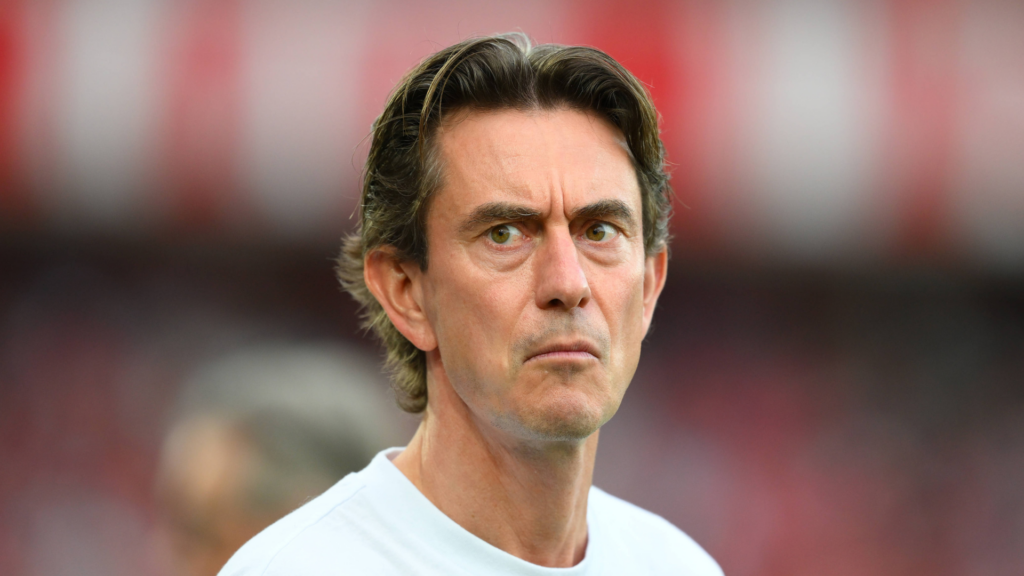 Tottenham manager Thomas Frank glances to his left with a stern expression on his face.