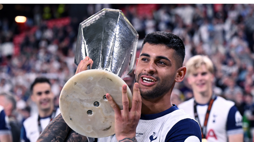 Tottenham defender Cristian Romero holding the Europa League trophy.