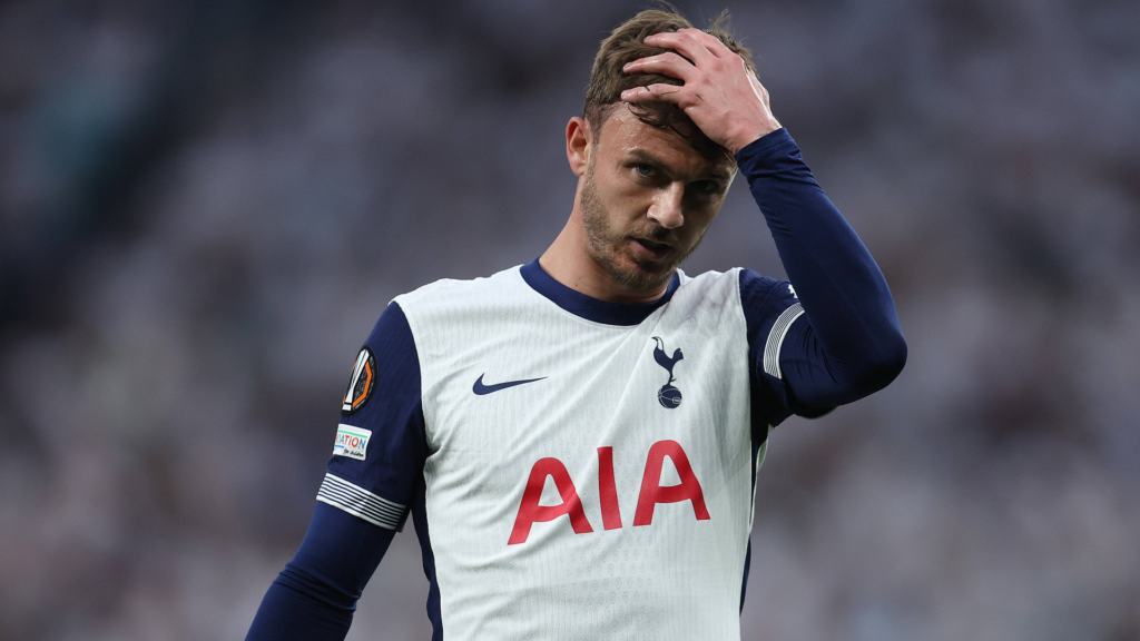 Tottenham midfielder James Maddison places his hand on his head.
