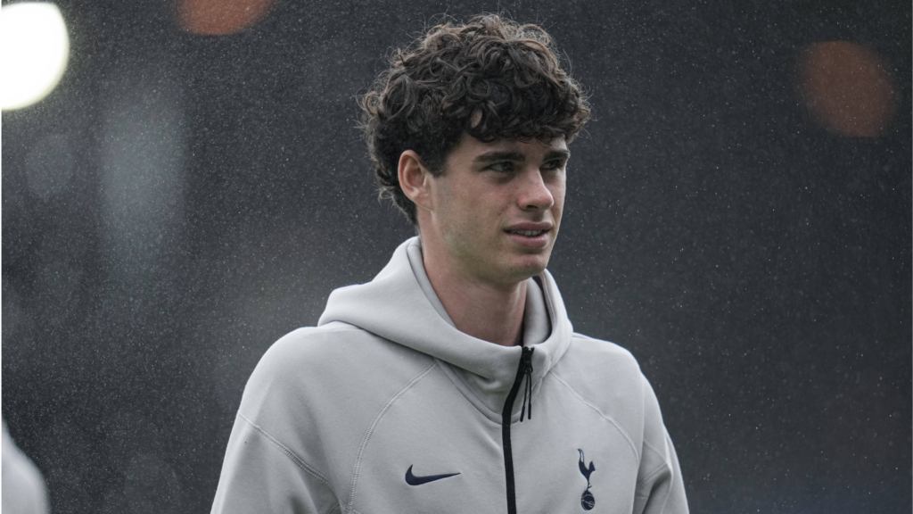 Archie Gray looking in the distance wearing a Tottenham tracksuit.