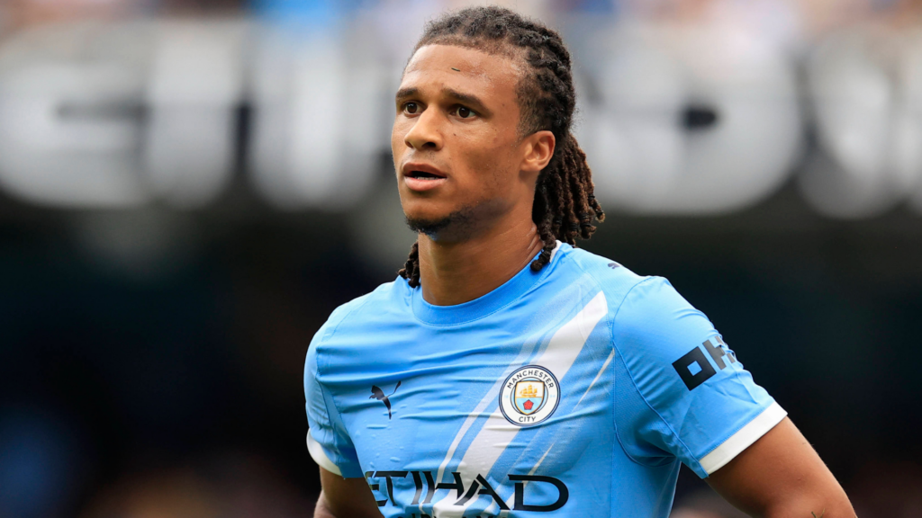Tottenham target Nathan Ake stands with his hands on his hips while in action for Manchester City.