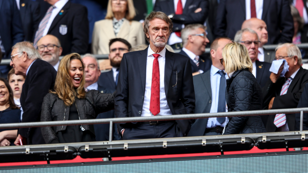 Manchester United and INEOS owner Sir Jir Ratcliffe stands on a balcony at a game.
