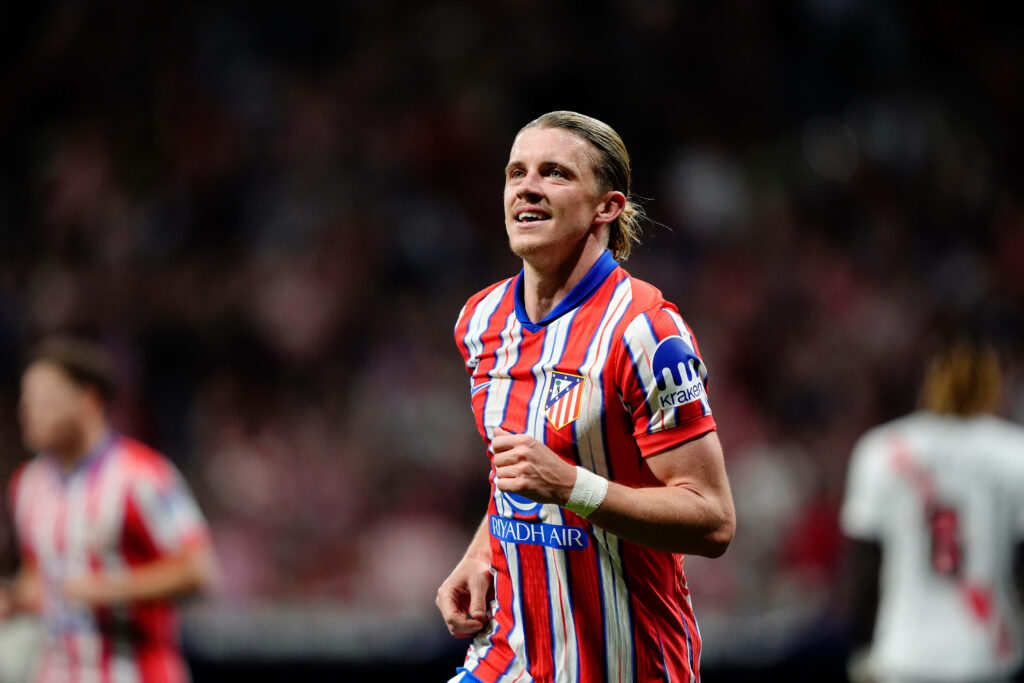 Conor Gallagher jogs with a smile on his face for Atletico Madrid.
