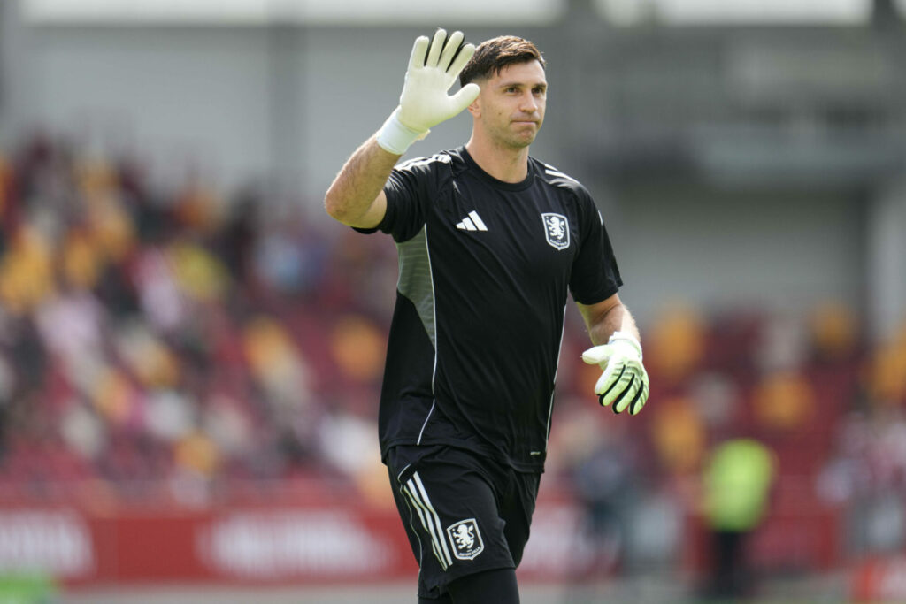 Emi Martinez waves in Aston Villa training gear.