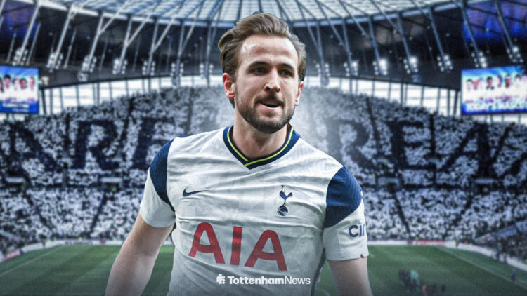 Harry Kane is pictured in the 2025/26 Tottenham home kit with the Tottenham Hotspur Stadium behind him.