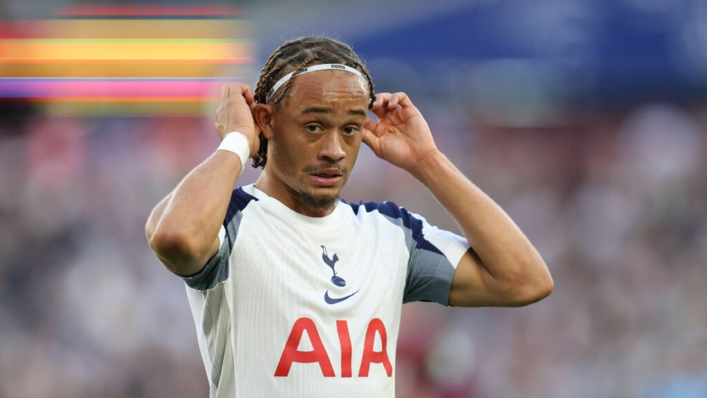 Xavi Simons holds his head band while playing for Tottenham.