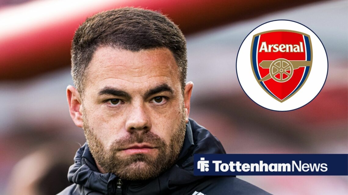 Martin Ho looking at Arsenal badge.