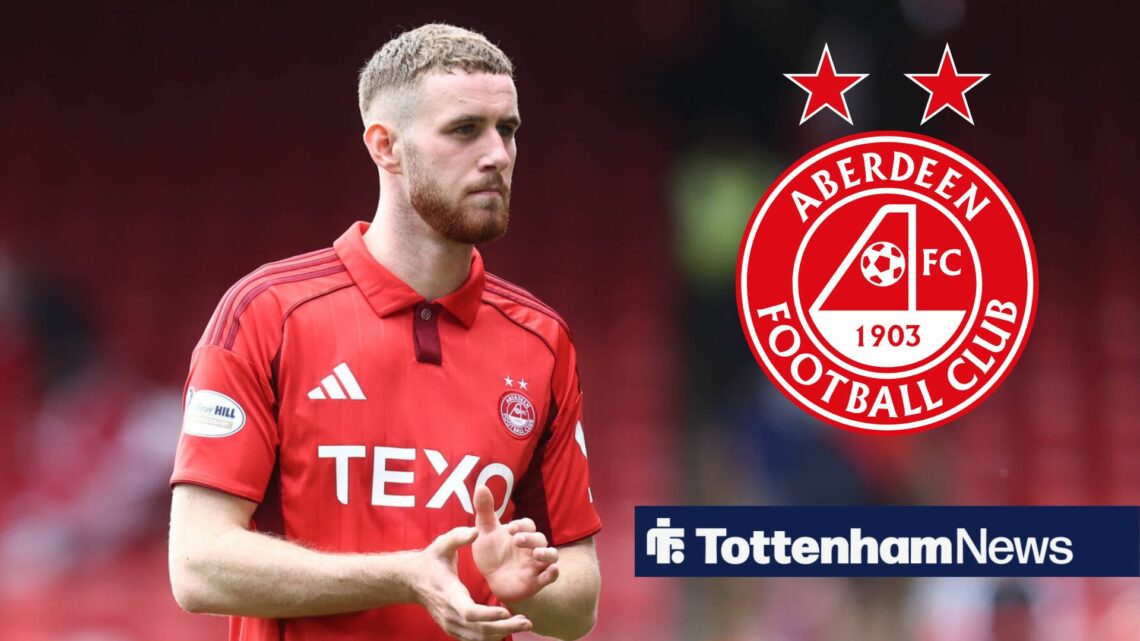 Alfie Dorrington claps, with the Aberdeen club crest alongside him