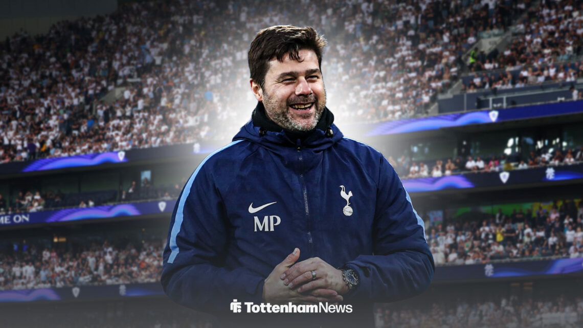 Mauricio Pochettino smiling in Tottenham gear in front of the Tottenham Hotspur Stadium.