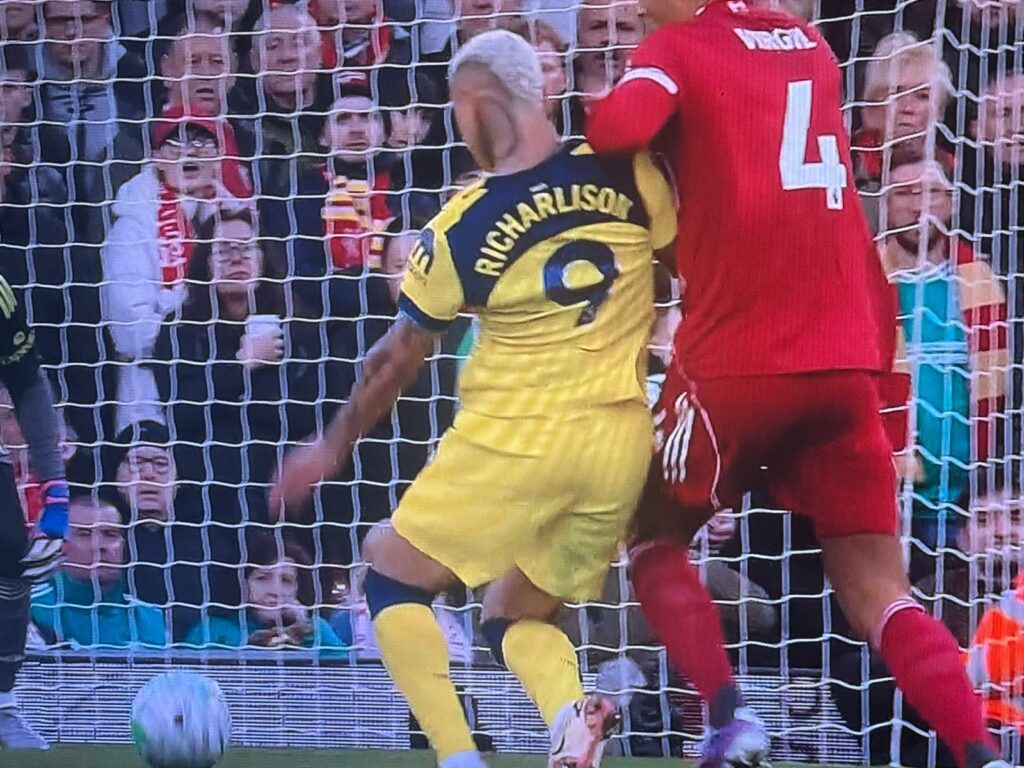 Liverpool defender Virgil van Dijk holds Richarlison as the Tottenham striker shoots at Anfield