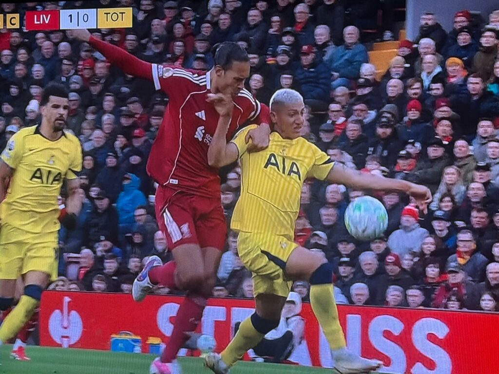 Tottenham striker Richarlison is held back by Liverpool defender Virgil van Dijk at Anfield